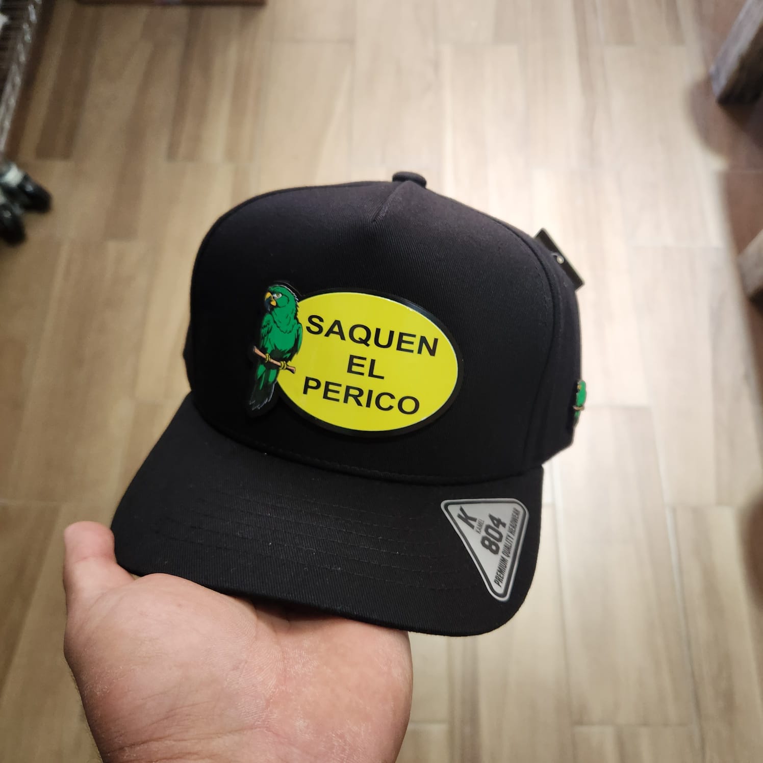 SAQUEN EL PERICO GORRA NEGRA PLACA KAMEL