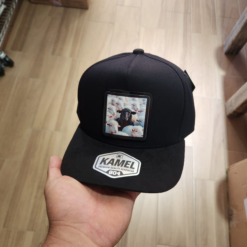 OVEJA NEGRA OVEJAS BLANCAS RETRATO GORRA NEGRA VICERA GAMUZA NEGRA PLACA KAMEL