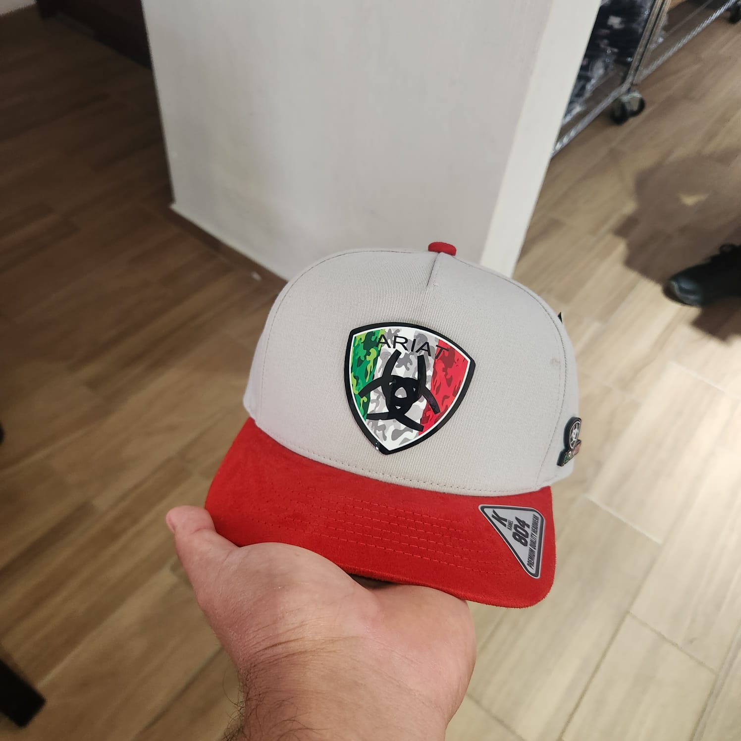 ARIAT LOGO TRICOLOR GORRA GRIS VICERA ROJA GAMUZA PLACA KAMEL