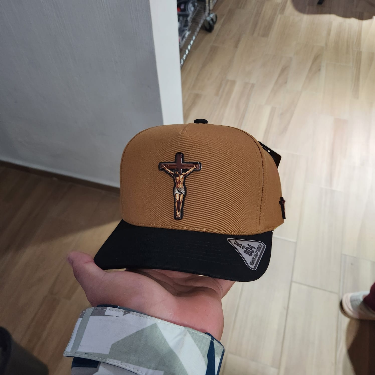 CRISTO CRUZ GORRA CAFE Y VICERA NEGRA PLACA KAMEL