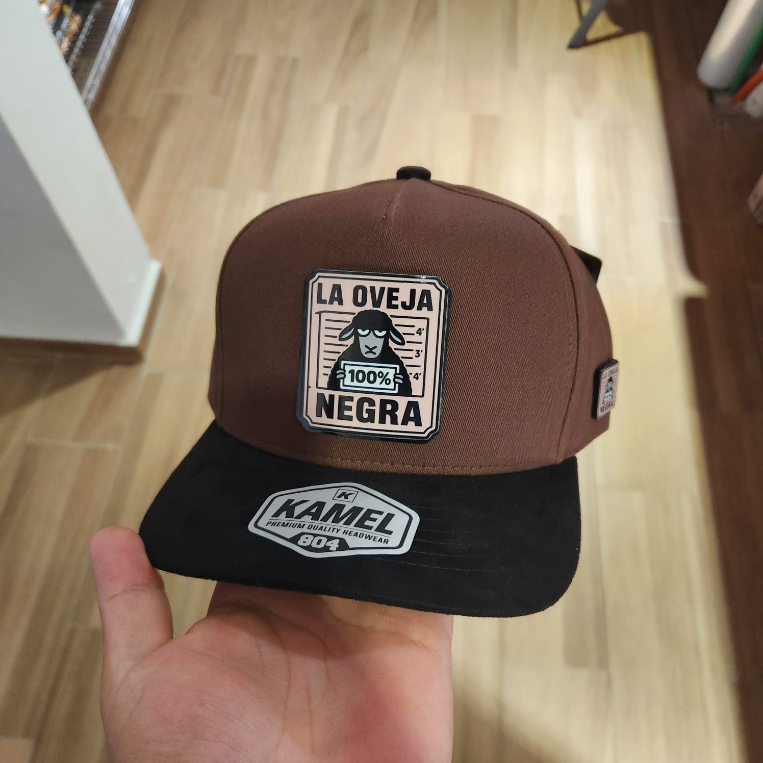LA OVEJA NEGRA GORRA CAFE VICERA GAMUZA NEGRA PLACA KAMEL